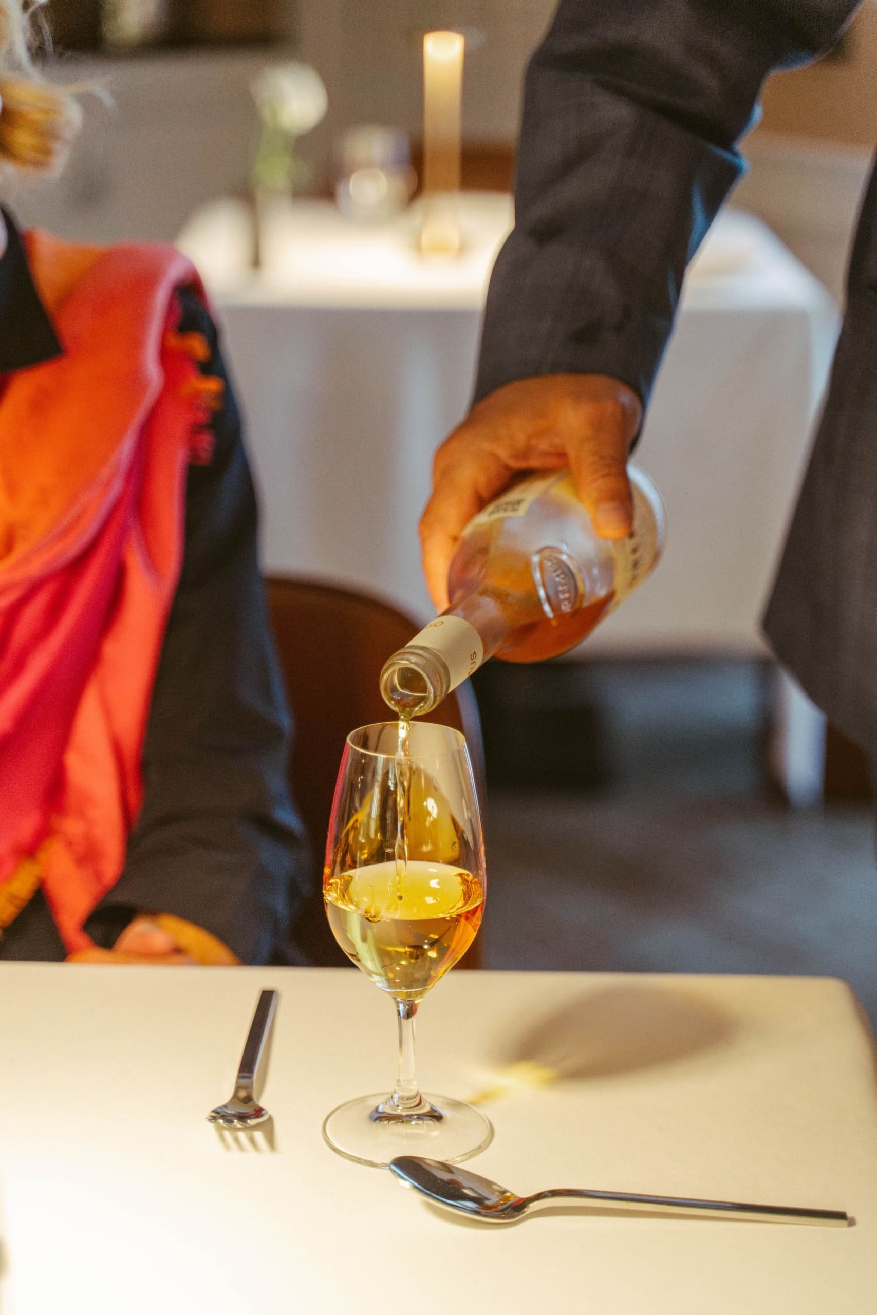 A server pouring a glass of white wine for a guest at the Chatham Inn