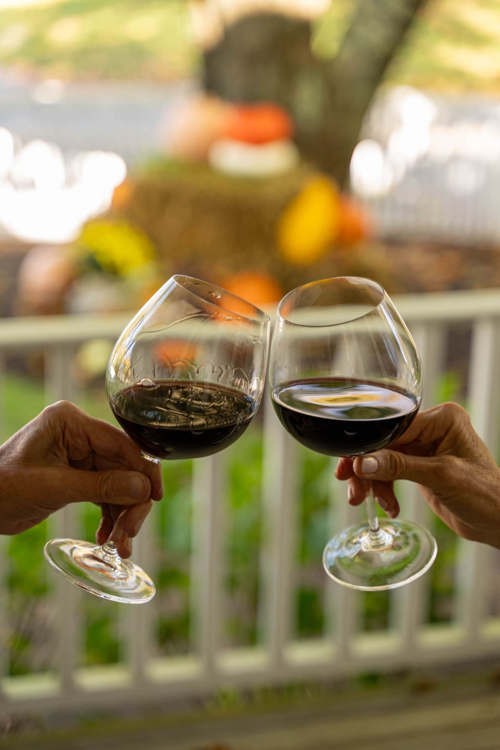 A couple enjoying glasses of red wine on a balcony at Chatham Inn