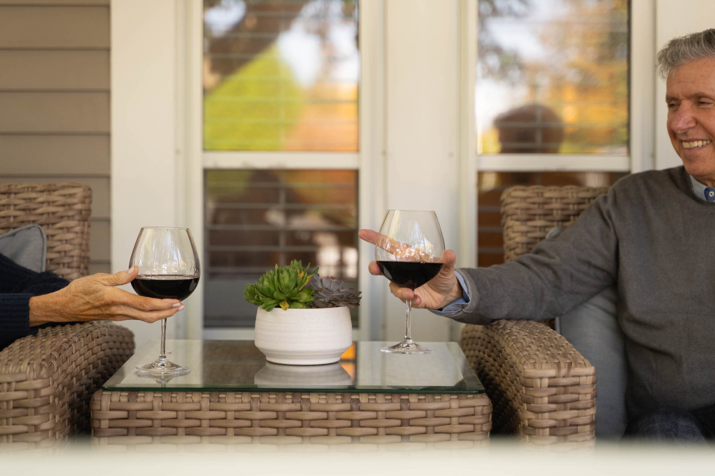 A couple having a glass of red wine on the patio at Chatham Inn during an event