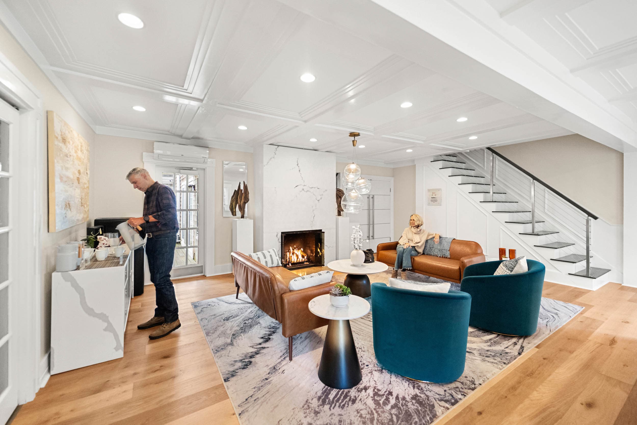 A man pouring some water in bright living space at Chatham Inn