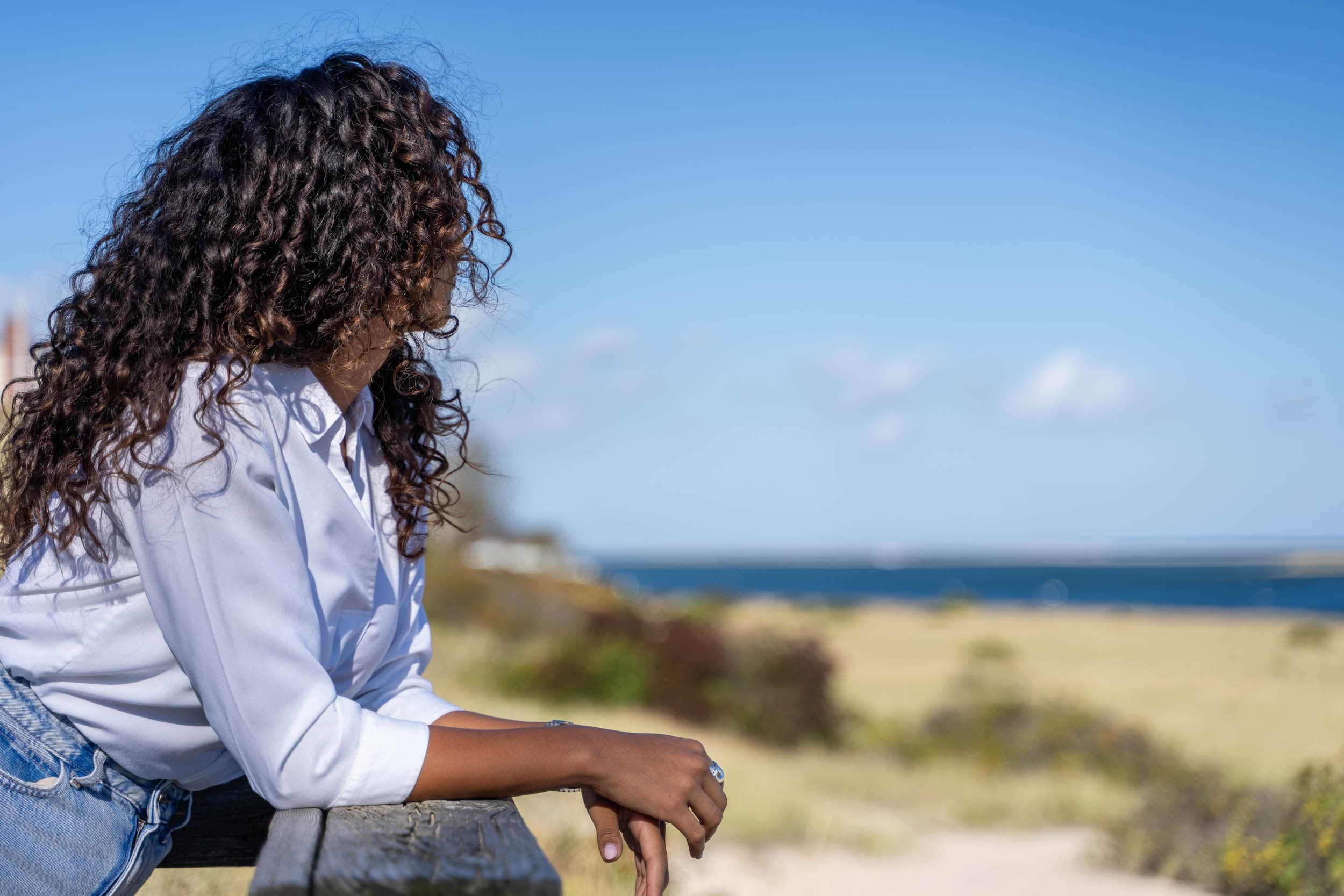 A woman leaning on a railing on a boardwalk staring out to the water during a local experience