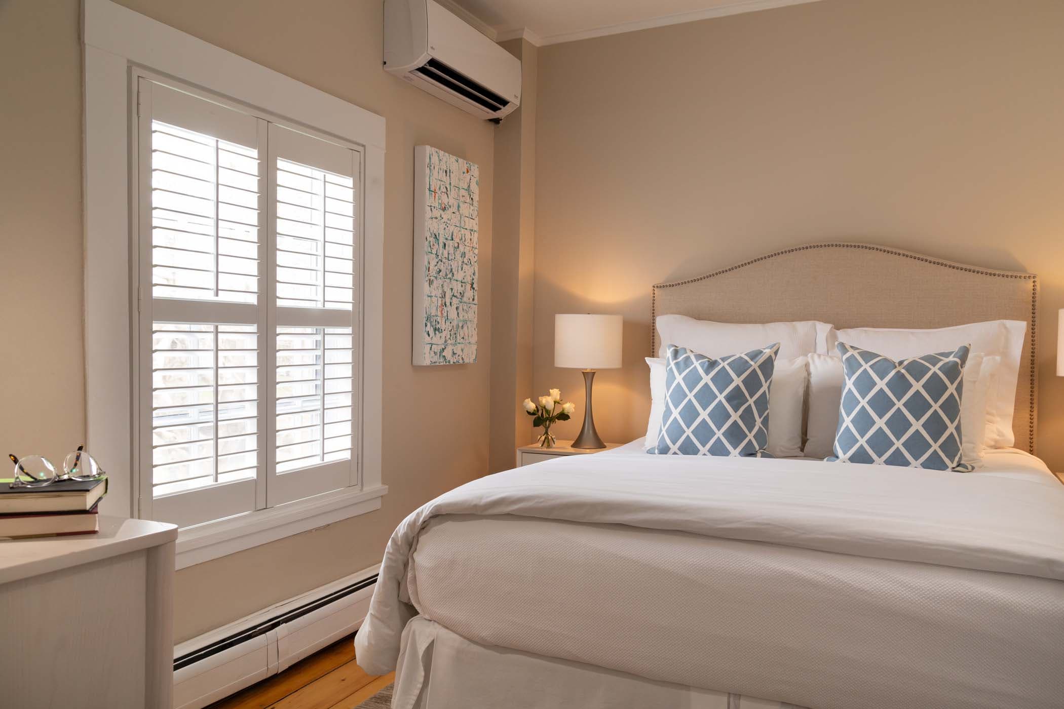 A queen bed and large windows providing beautiful light in Room 15 at Chatham Inn