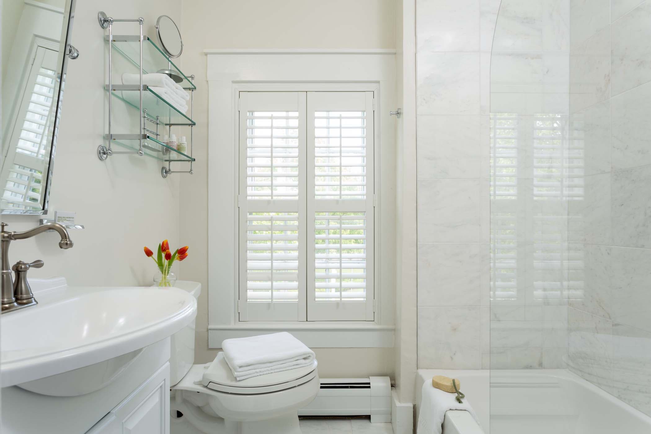 A spacious room 15 bathroom with a bouquet of flowers at Chatham Inn