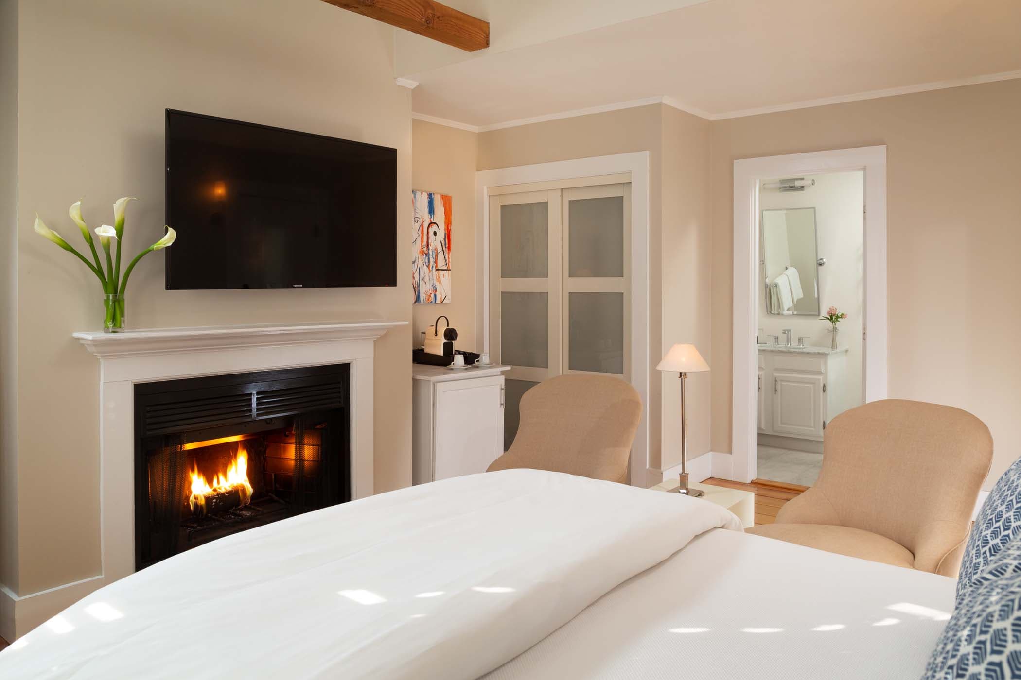 A fireplace at the end of the bed in Room 18 at Chatham Inn