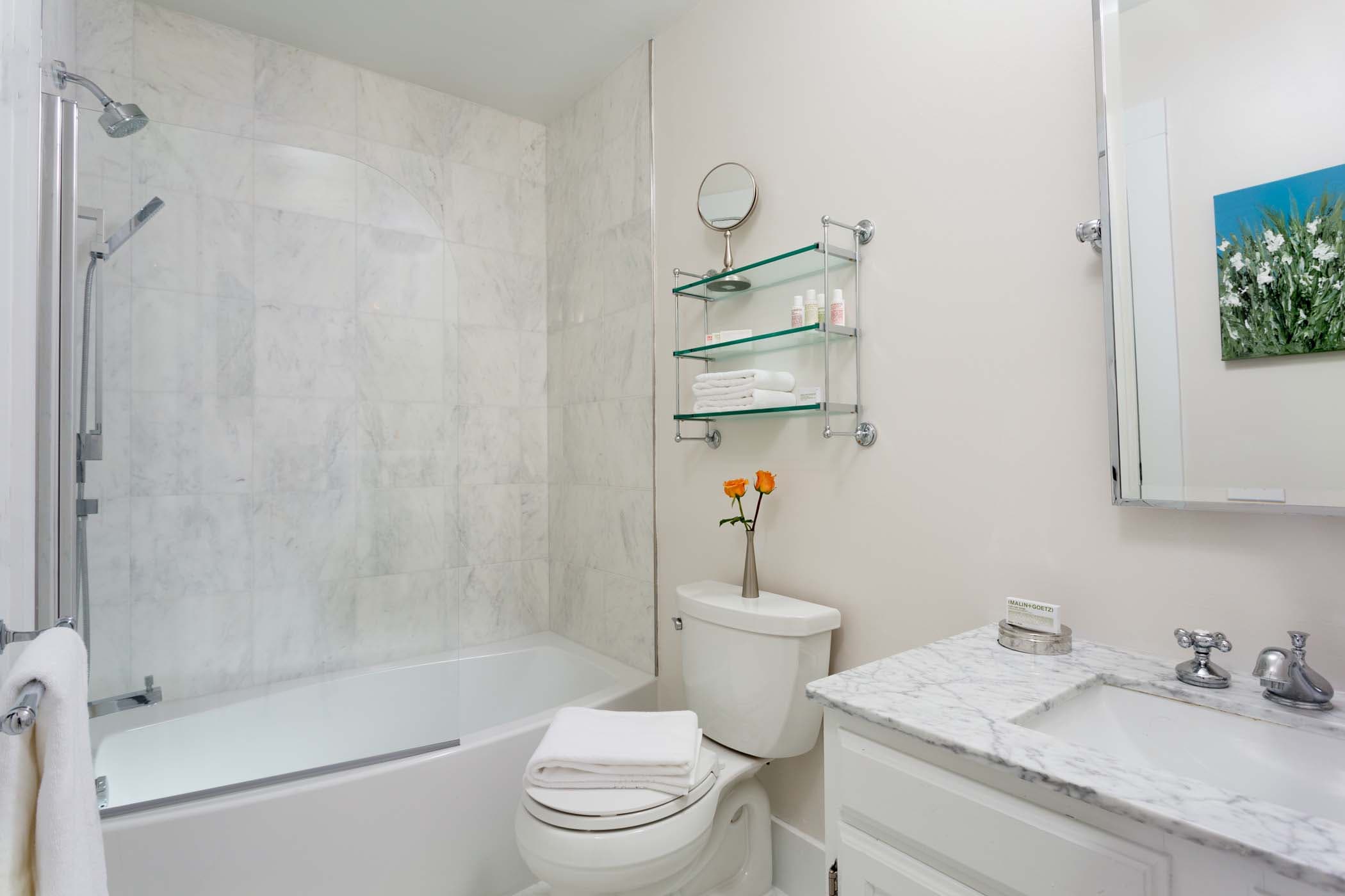 A spacious room 10 bathroom with 2 flowers at Chatham Inn