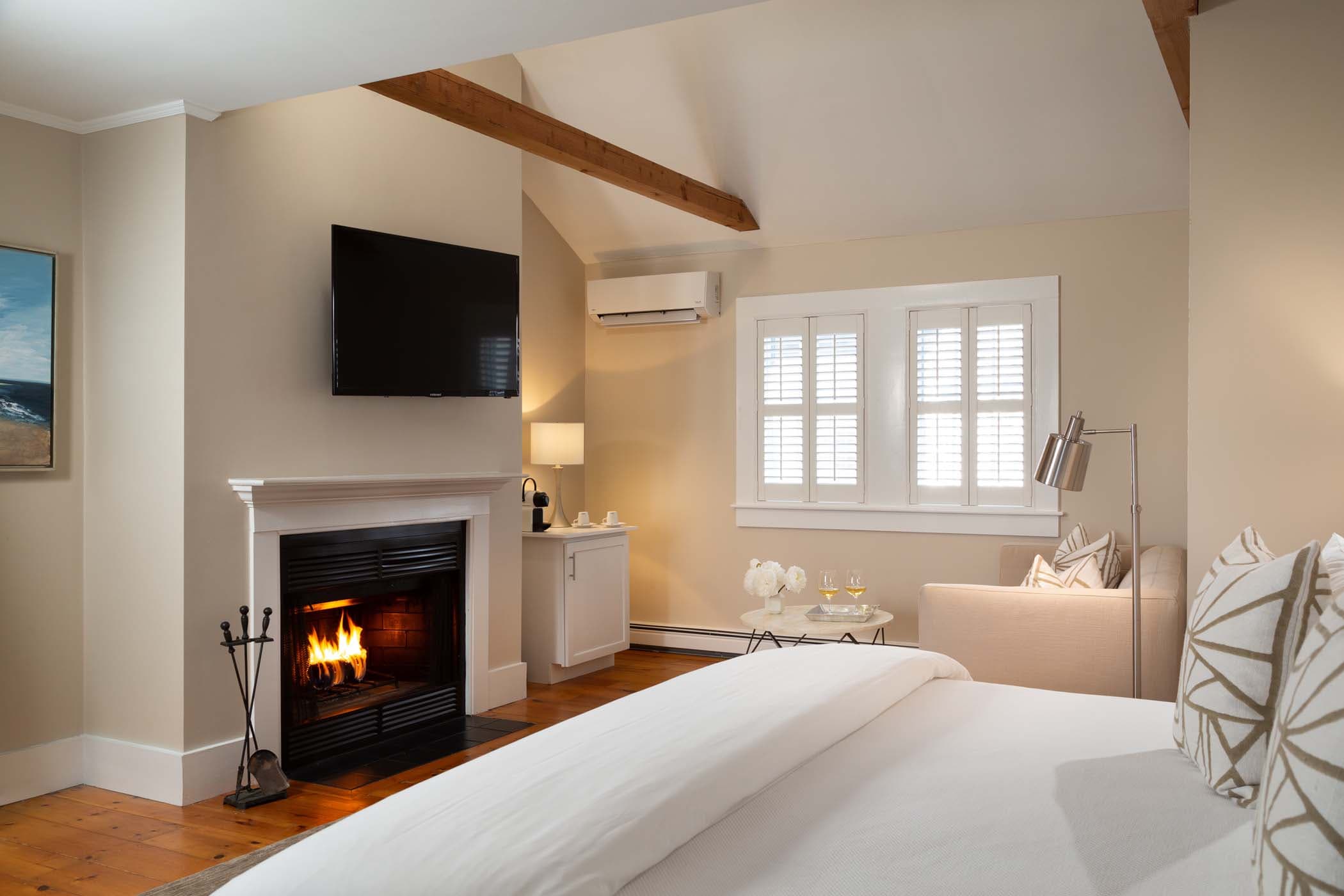 A large bed, fireplace and coffee counter in Room 19 at Chatham Inn