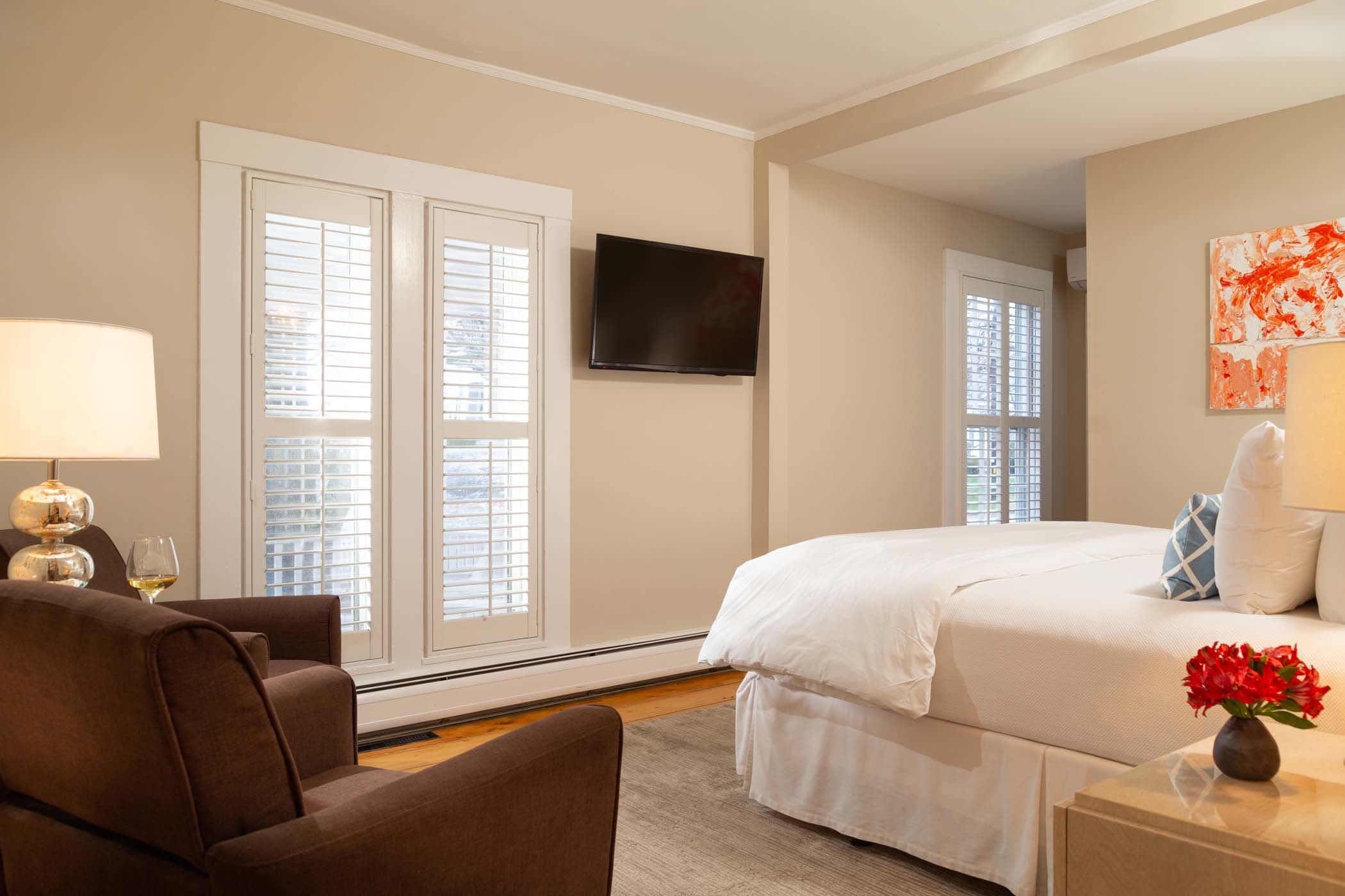 Room 6 with vibrant wall art, a mounted Tv, and a sitting area at Chatham Inn