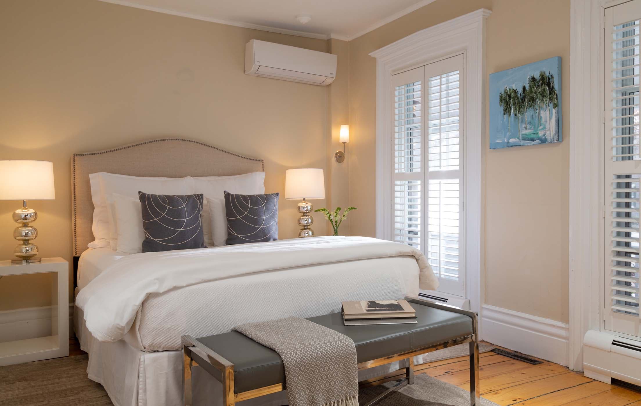 A bed in Room 7 with an end of the bed bench and large windows at Chatham Inn