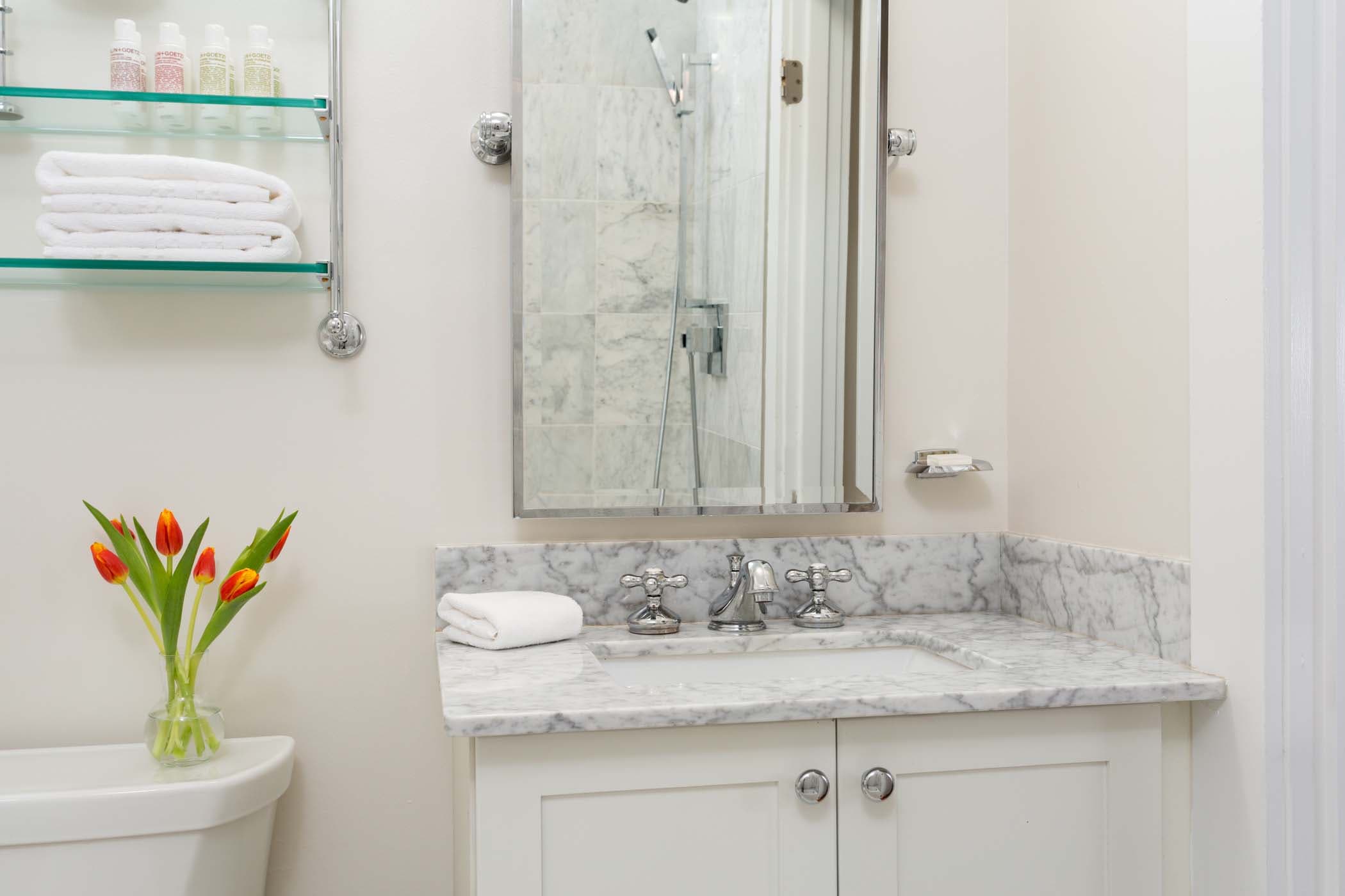 A spacious room 8 bathroom with 6 red tulips at Chatham Inn