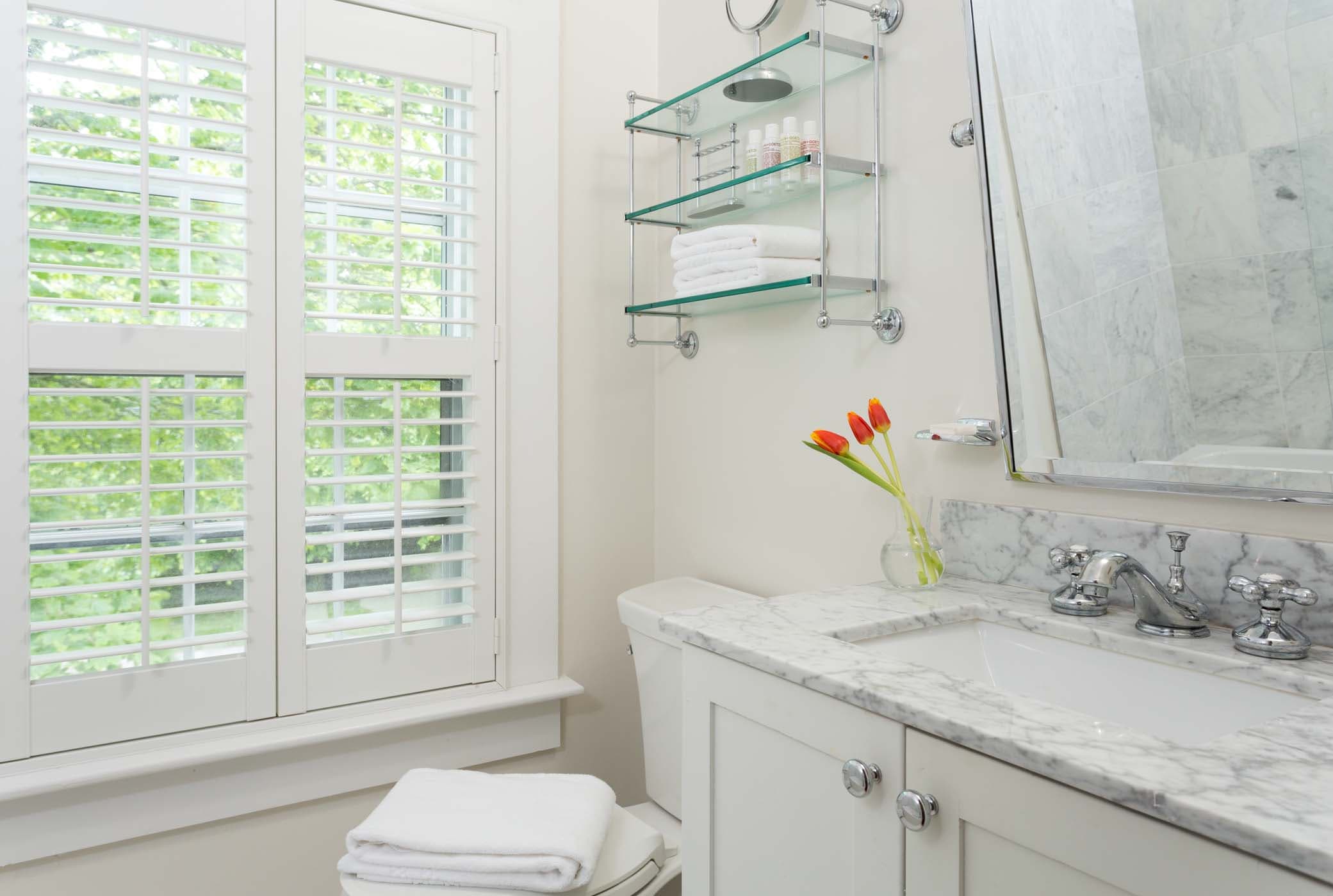 A spacious room 9 bathroom with 3 red tulips at Chatham Inn