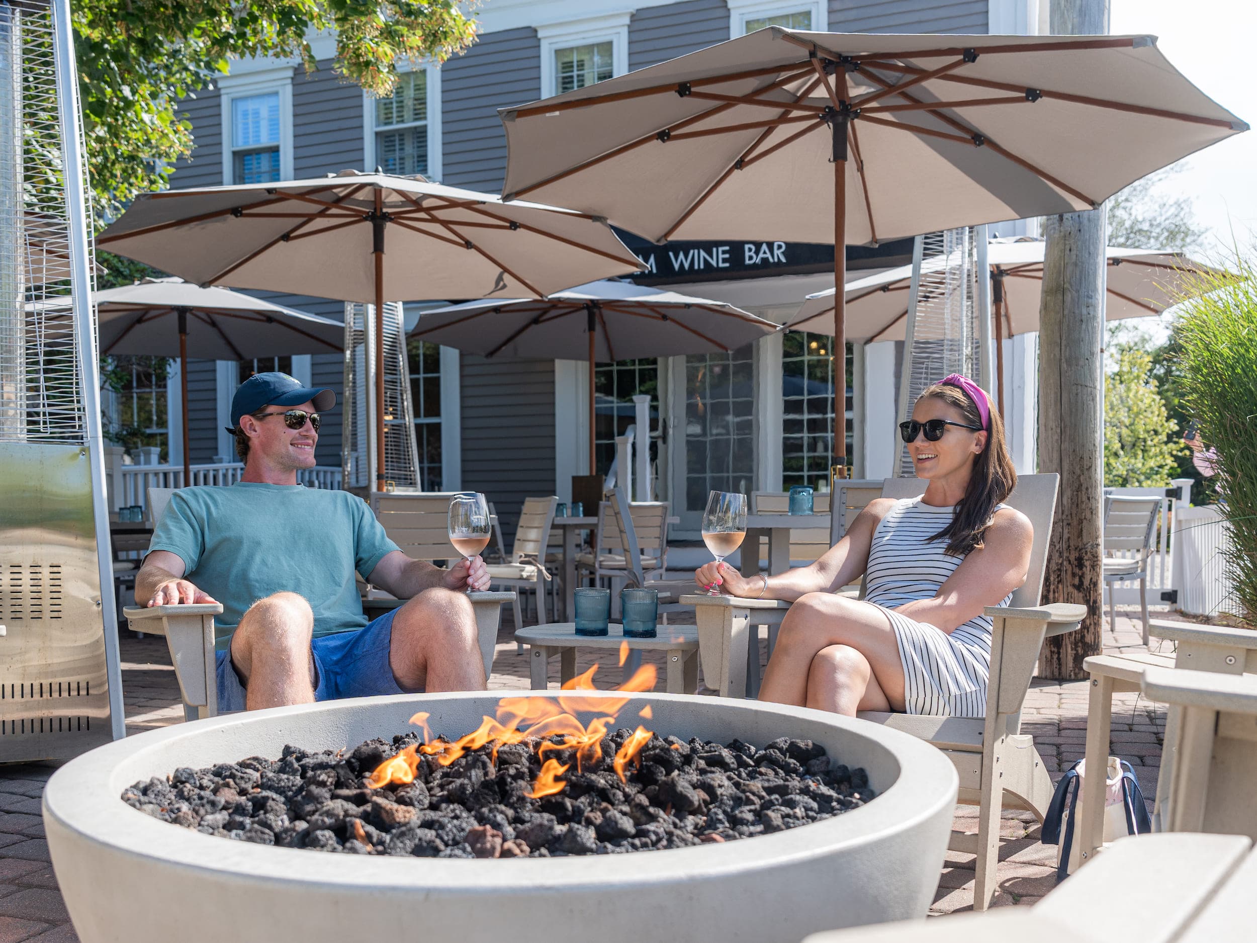 A couple having a glass of rosé at the Wine Bar patio at Chatham Inn, part of the signature amenities