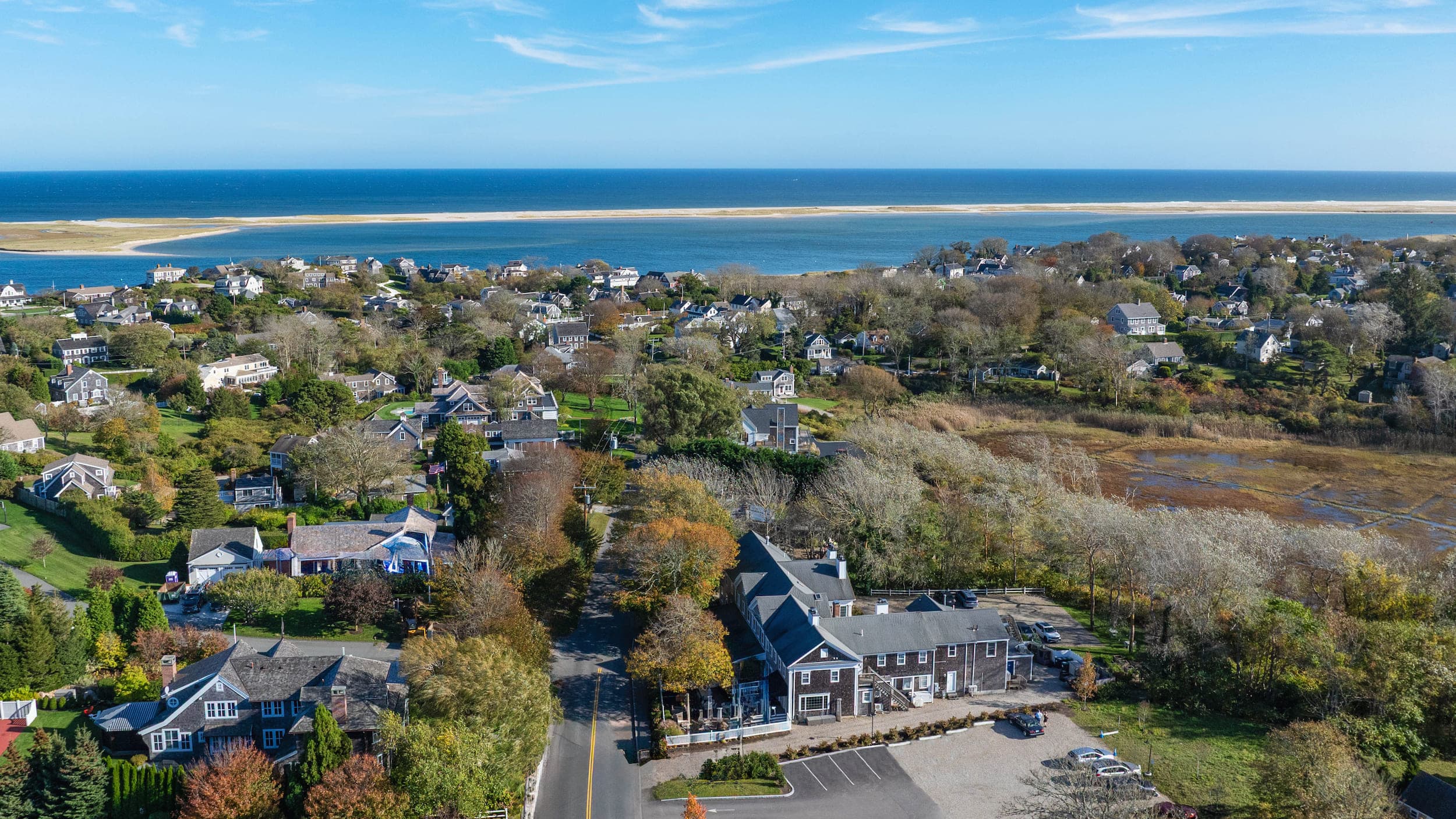 An aerial view of Cape Cod with houses and a large body of water