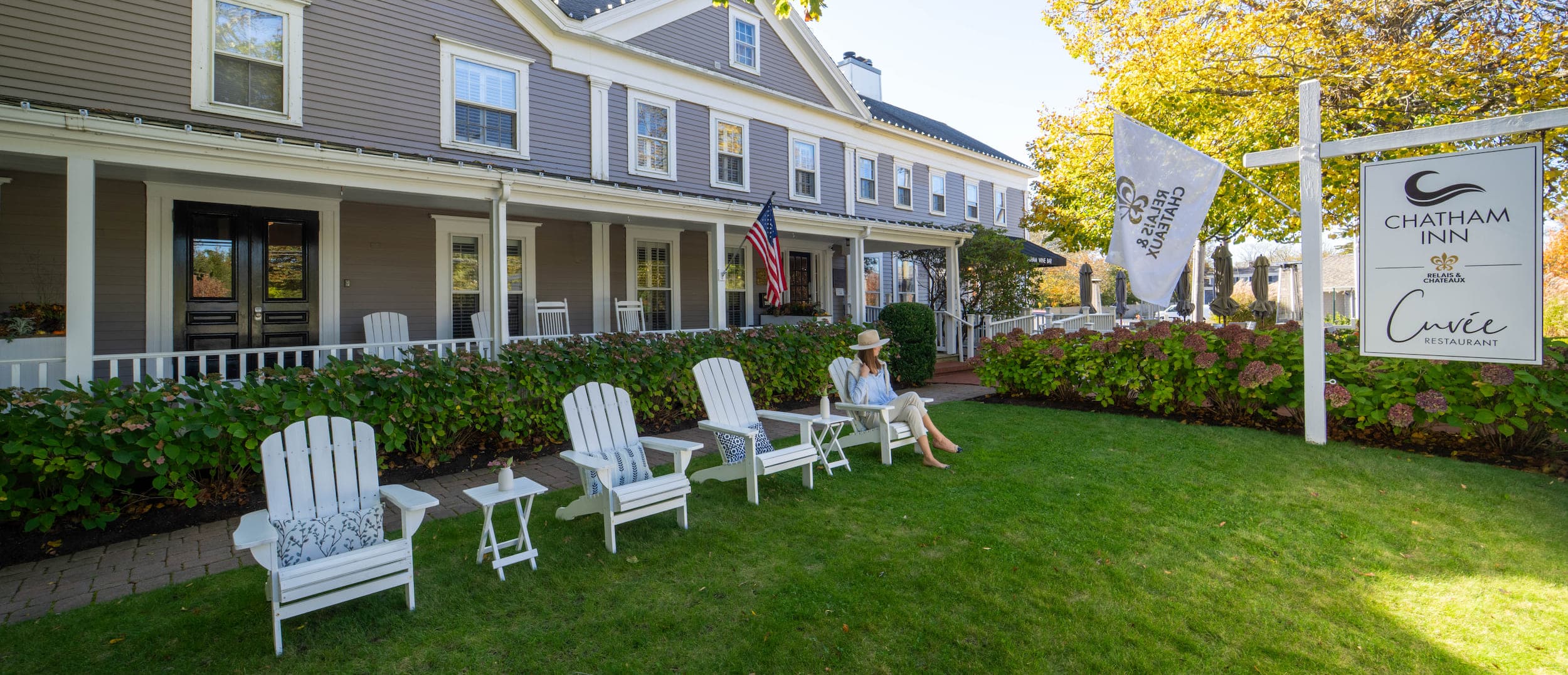 A woman sitting in a lawn chair out front of Chatham Inn