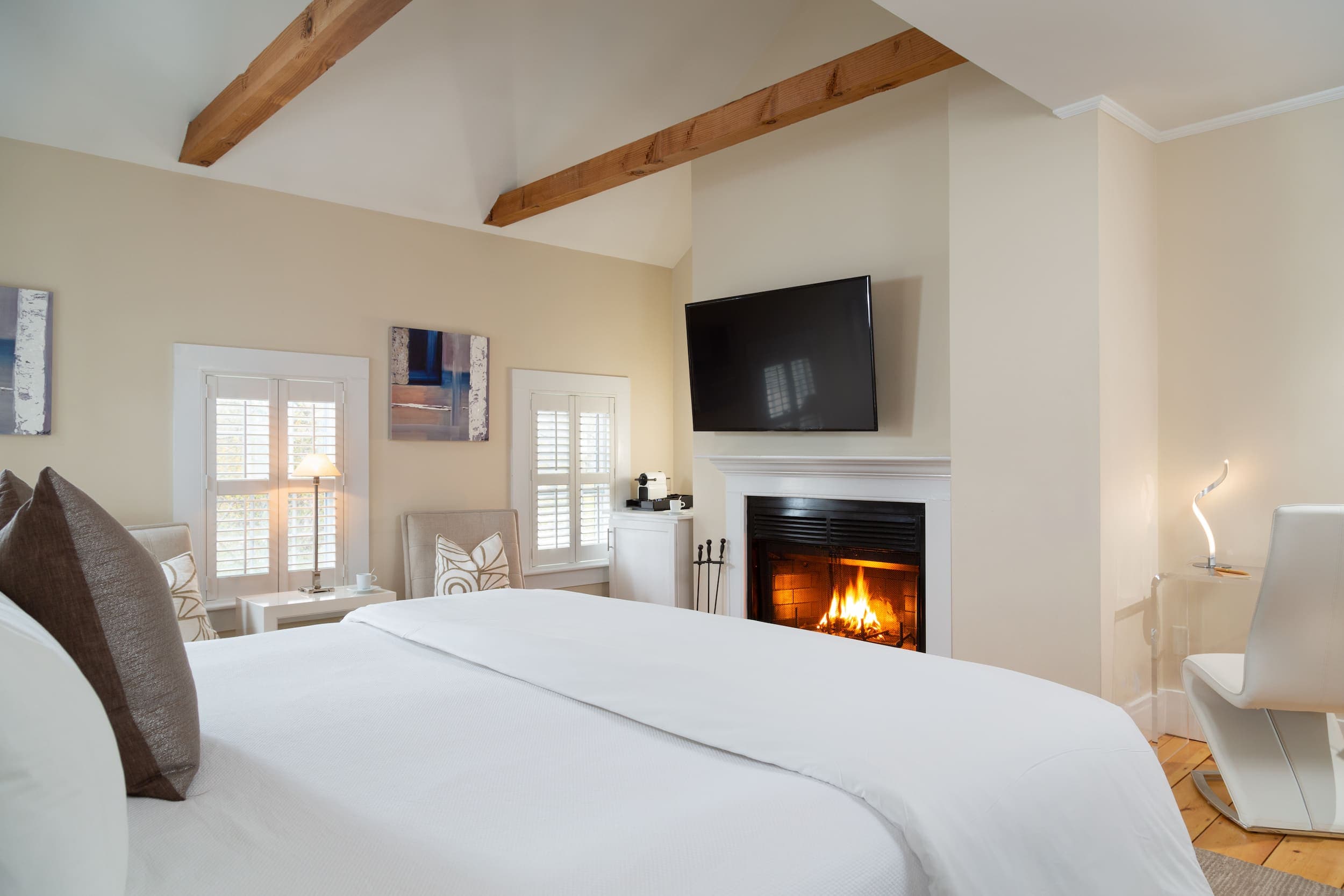 A large bed, lounge area, and a fireplace in Room 16 at Chatham Inn