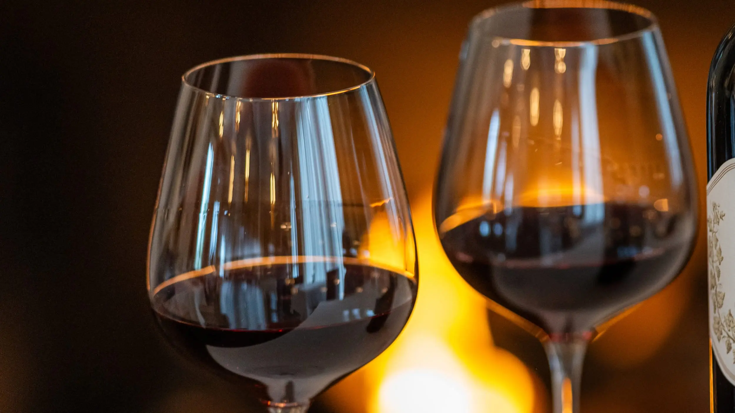 Two glasses of red wine in front of an in-room fireplace at Chatham Inn